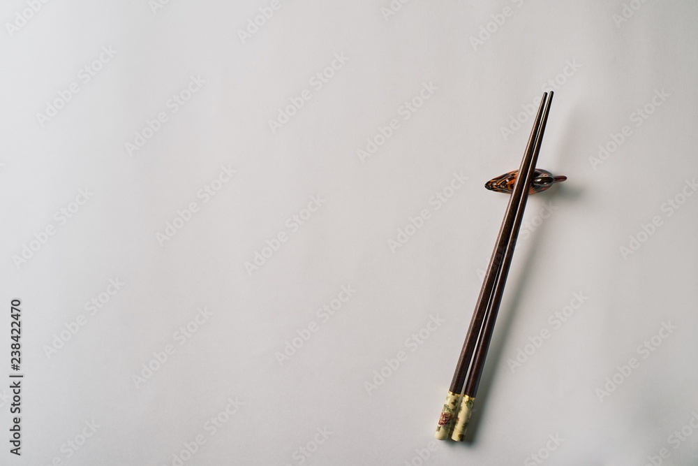 Fototapeta premium Wooden chopsticks with stand, isolated on white background