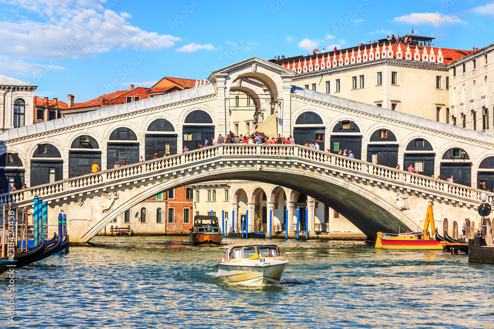 The Rialto Bridge of Venice with gondolas, vaporetto and boats u