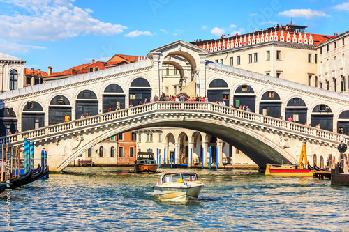 The Rialto Bridge of Venice with gondolas, vaporetto and boats u © AlexAnton