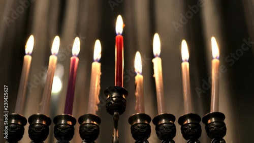 Nine candles in hanukkiah are burning on light curtain background on the last eighth day of the Jewish holiday Hanukkah. Selective focus. 4k photo