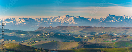 Autumnal hills and vineyards in Langhe Monferrato region with mountains on background in Piedmont, Northern Italy.
