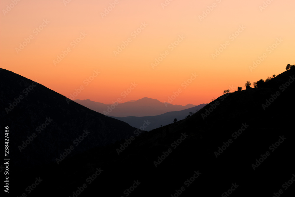 idyllic beautiful landscape of sunset between mountains highland space with clear orange sky, wallpaper pattern and copy space