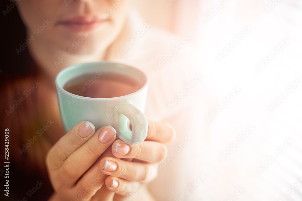 drinking tea sitting on the window of Caucasian beautiful middle-aged woman with red hair, toning drinking tea sitting on the window of Caucasian beautiful middle-aged woman with red hair, toning