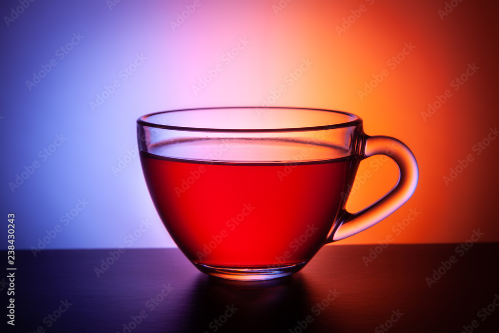 A transparent glass cup of tea stands on the table. A transparent glass cup of tea stands on the table.