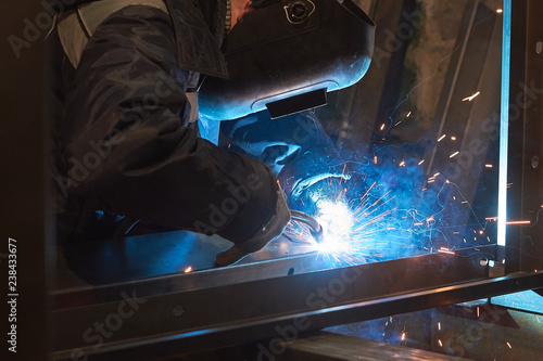 welder welds a metal frame for the power plant.