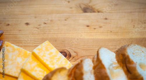 juicy chicken fillet on a wooden board, boneless skinless, with pieces of marble cheese and bread, close-up