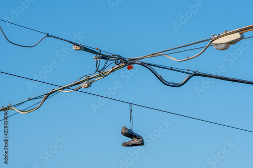 shoes hanging from electric line with blue sky background