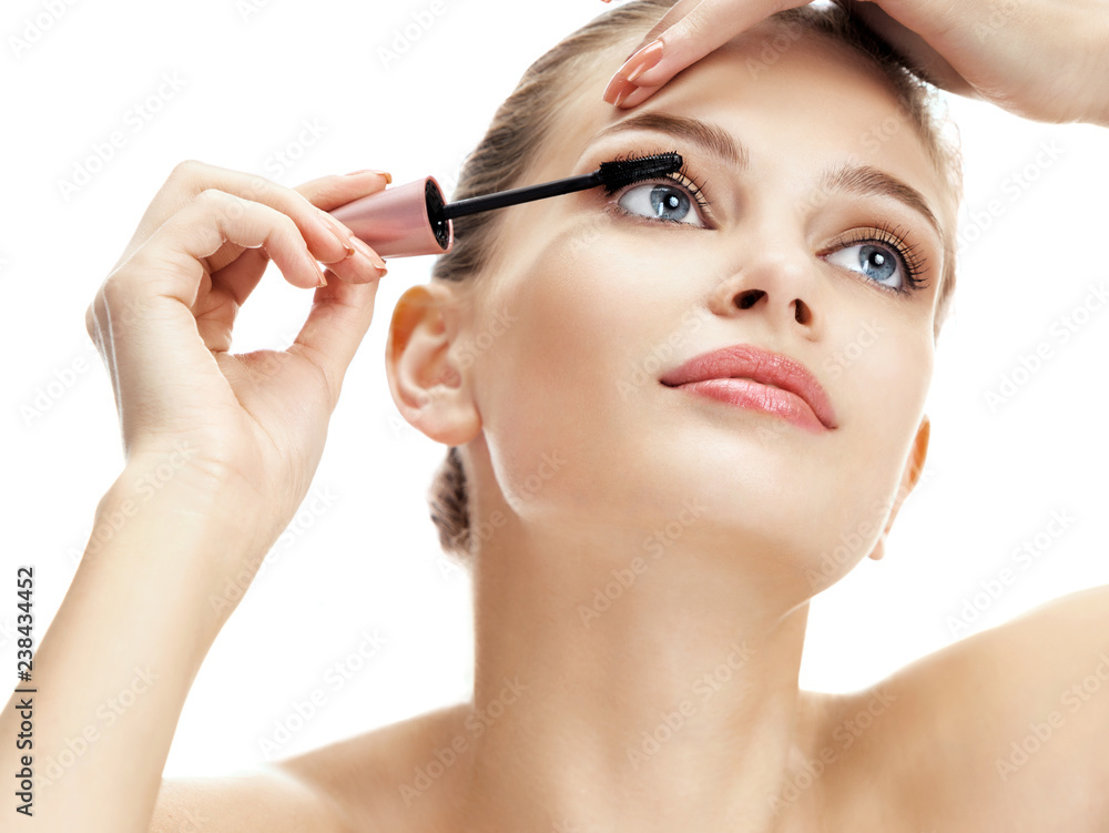 Woman using black mascara on eyelashes isolated on white background. Beauty concept