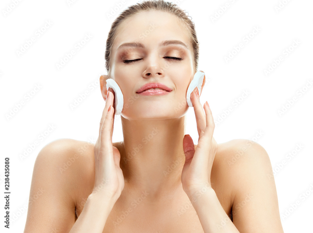 Beautiful woman holds cotton pads near face on white background. Skin care concept