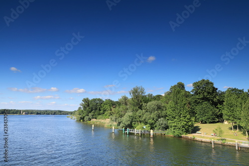 a river and blue sky with city park