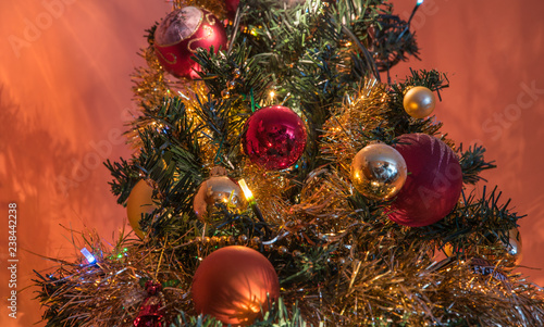 Portion of a lighten up Christmas Tree, with red, gold and silver balls. Also red and gold ribbons are present.