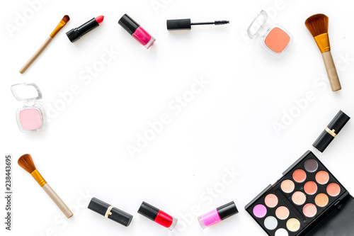 visagiste desk with decorative cosmetics: eyeshadows, lipstick, brush white background top view space for text