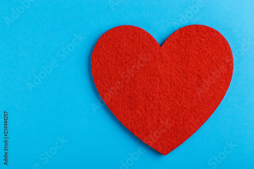 Red felt heart on bright blue background. St. Valentine's day