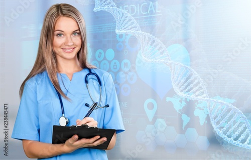 Young woman doctor with stethoscope writting on black tablet