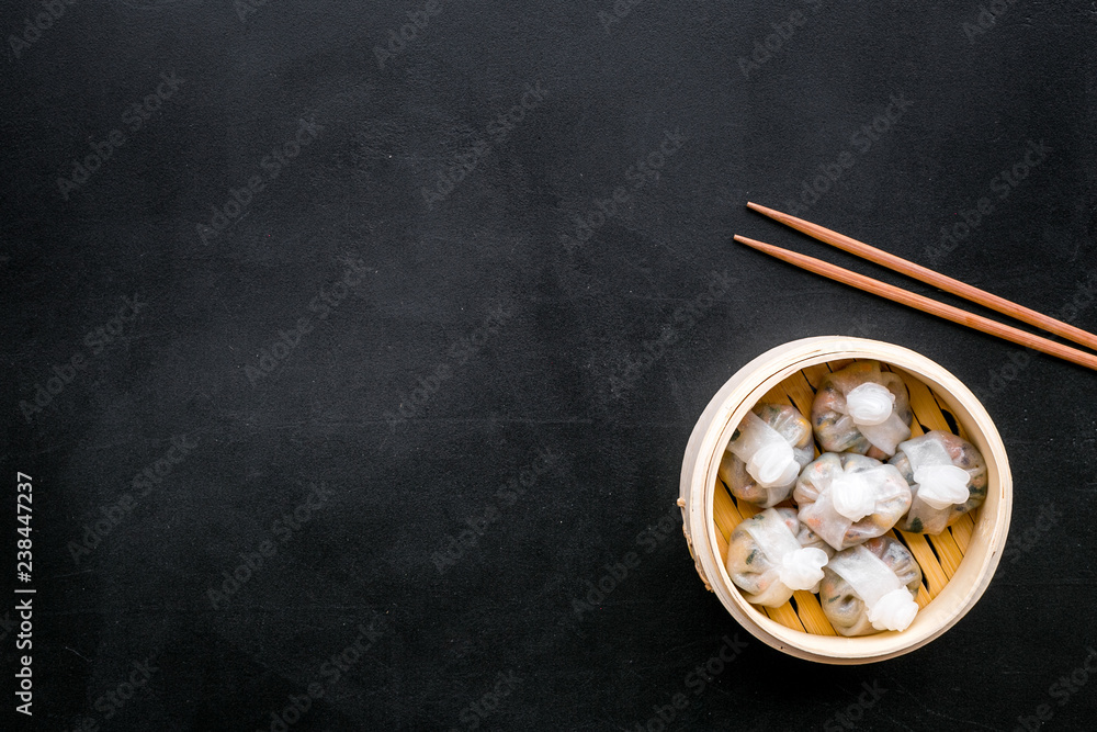 Dim sums with red pepper and vegetables with sticks in Chinese restaurant on black background top view mockup Dim sums with red pepper and vegetables with sticks in Chinese restaurant on black background top view mockup
