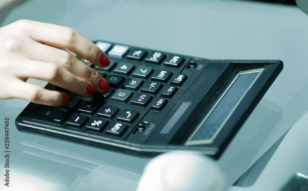 .closeup.business woman using a calculator at the workplace. .closeup.business woman using a calculator at the workplace.