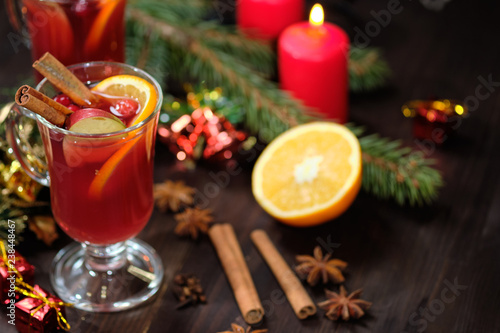 Mulled wine on a wooden background with candles  pine branches and Christmas lights. Selective focus