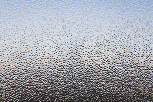 The frozen drops on the patterned frosty winter window