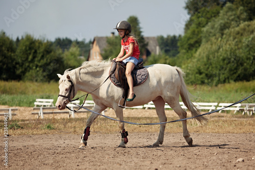 A young girl and white pony horse in countrysinde, Lithuania