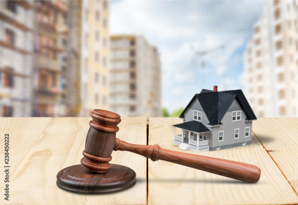 Wooden judge gavel and toy house on background Wooden judge gavel and toy house on background