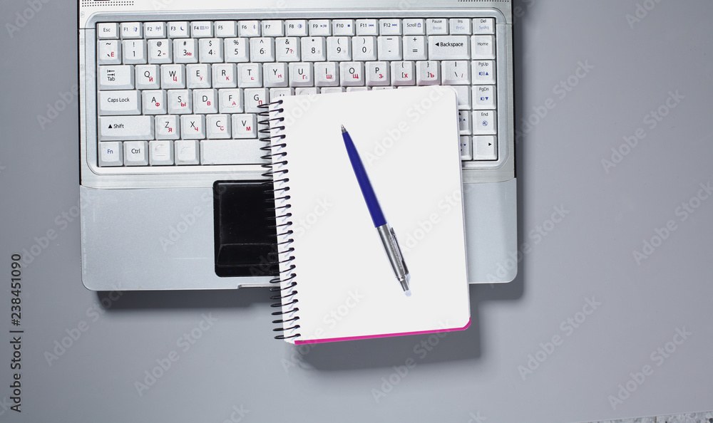 Office desk with blank notebook, computer keyboard and other office supplies Office desk with blank notebook, computer keyboard and other office supplies