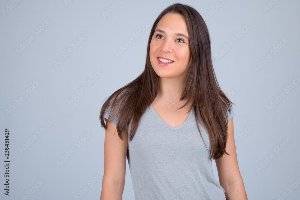 Young happy multi-ethnic woman smiling and thinking against white background Young happy multi-ethnic woman smiling and thinking against white background
