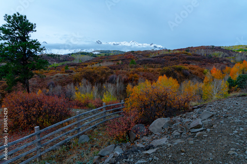 Brilliant fall colors at sunset below snowy mountain ranges