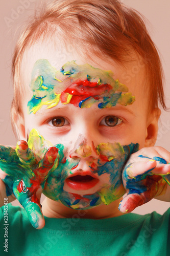 Fototapeta Naklejka Na Ścianę i Meble -  Close up portrait of hands and face painted in colorful paints. Children's meykap. Humorous portrait.