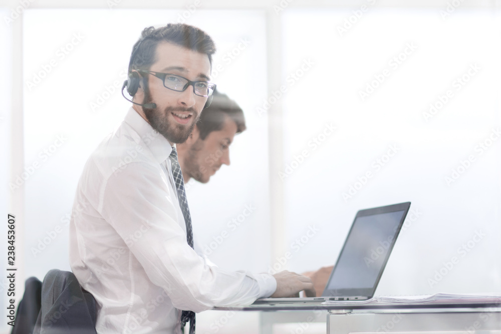 business man in headphones sitting at his Desk business man in headphones sitting at his Desk