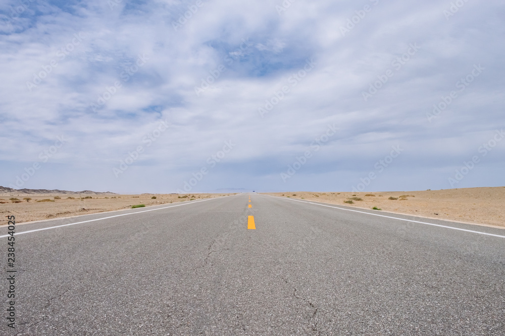 Road leading to horizon in gobi desert near Dunhuang, Gansu, in northwestern China