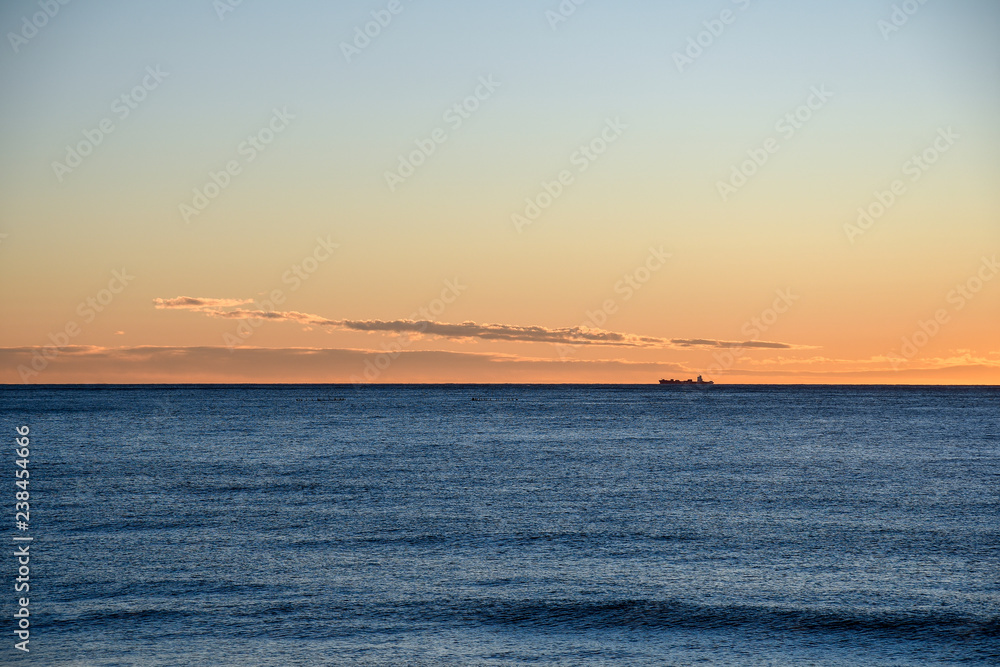 View of Mediterranean Sea with a ship on the horizon at sunset, Alassio, Liguria, Italy