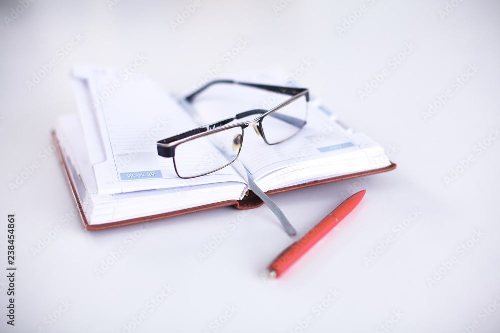 Open Notepad, pen and glasses on the table Open Notepad, pen and glasses on the table