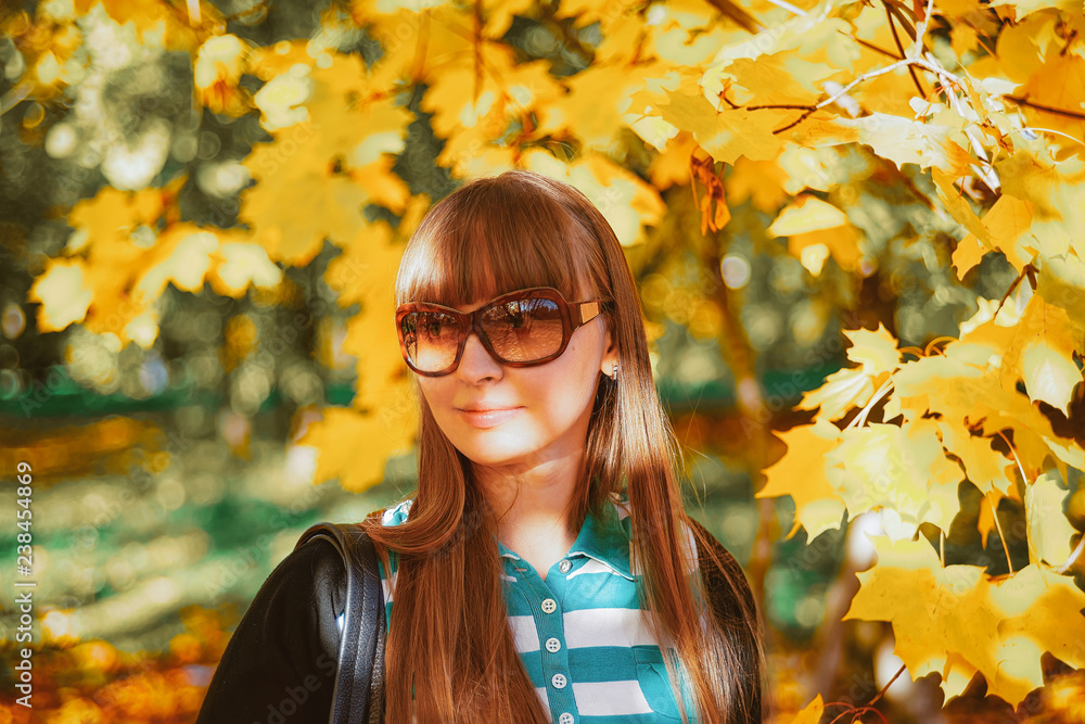 Young happy smiling girl in sunglasses near autumn maple leaves Young happy smiling girl in sunglasses near autumn maple leaves