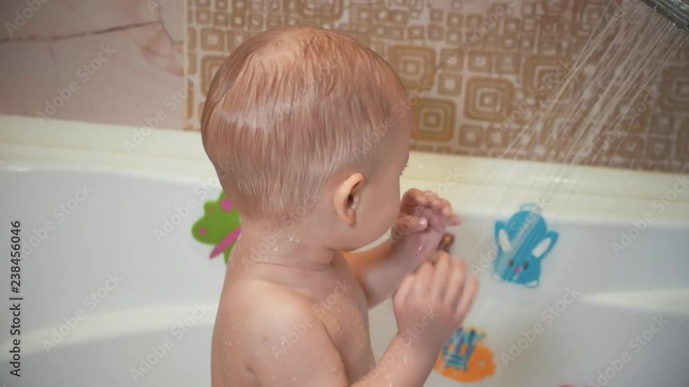 Cute little boy taking bath and douche. Little child in a bathtub. Smiling kid in bathroom with colorful toy. Infant washing and bathing. Hygiene and care for young children. Cute little boy taking bath and douche. Little child in a bathtub. Smiling kid in bathroom with colorful toy. Infant washing and bathing. Hygiene and care for young children.
