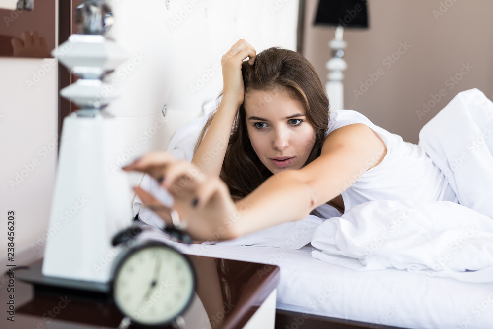 Happy woman waking up and turning off the alarm clock having a good day. Wake up. Happy woman waking up and turning off the alarm clock having a good day. Wake up.