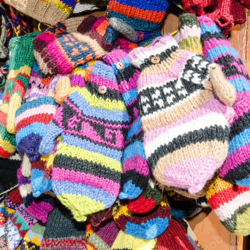 Multicolored hand-knitted woolen mittens and gloves on the market