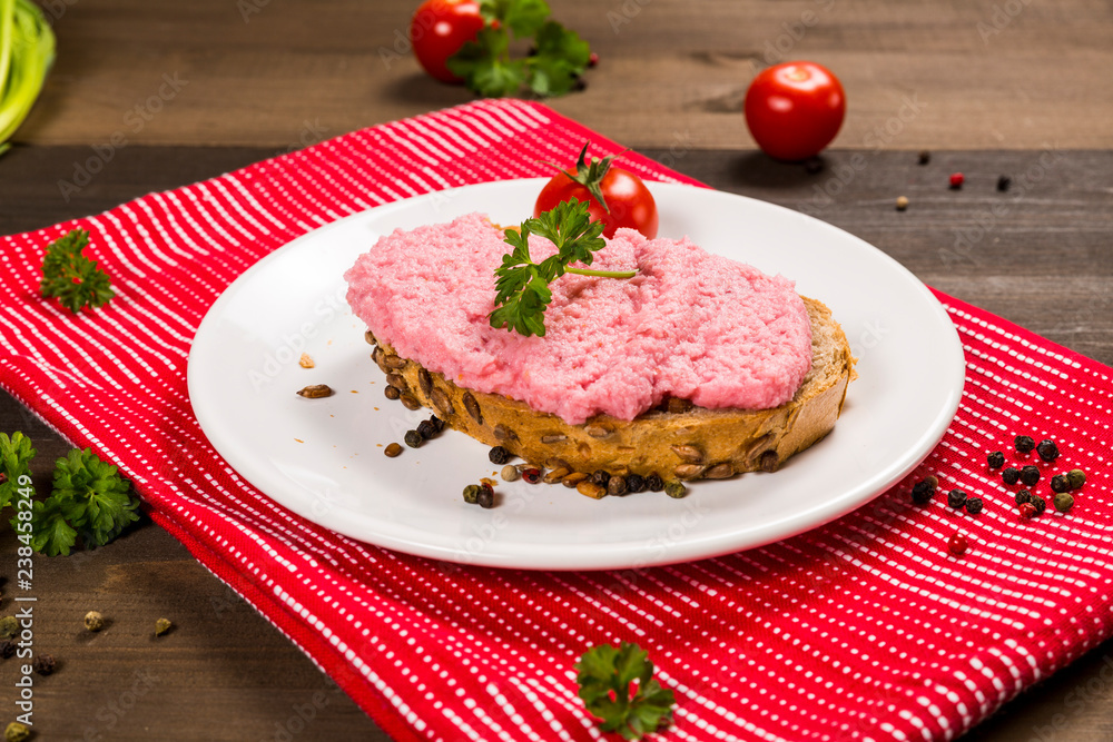 Sandwich with pink paste and tomato on the plate 
