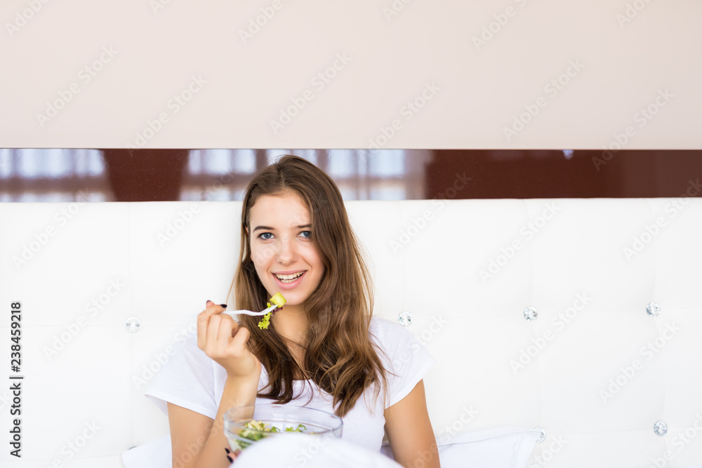 Young woman in bed eating health breakfast in the morning Young woman in bed eating health breakfast in the morning