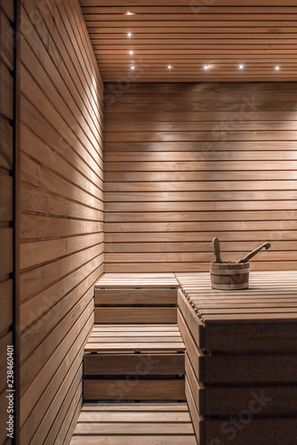 Illuminated wooden sauna with bucket and ladle