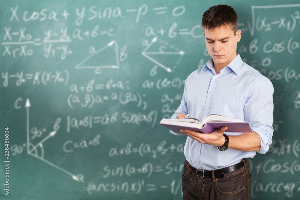 Young male teacher standing with book Young male teacher standing with book
