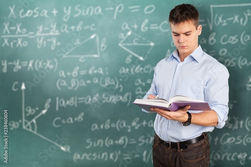 Young male teacher   standing with book