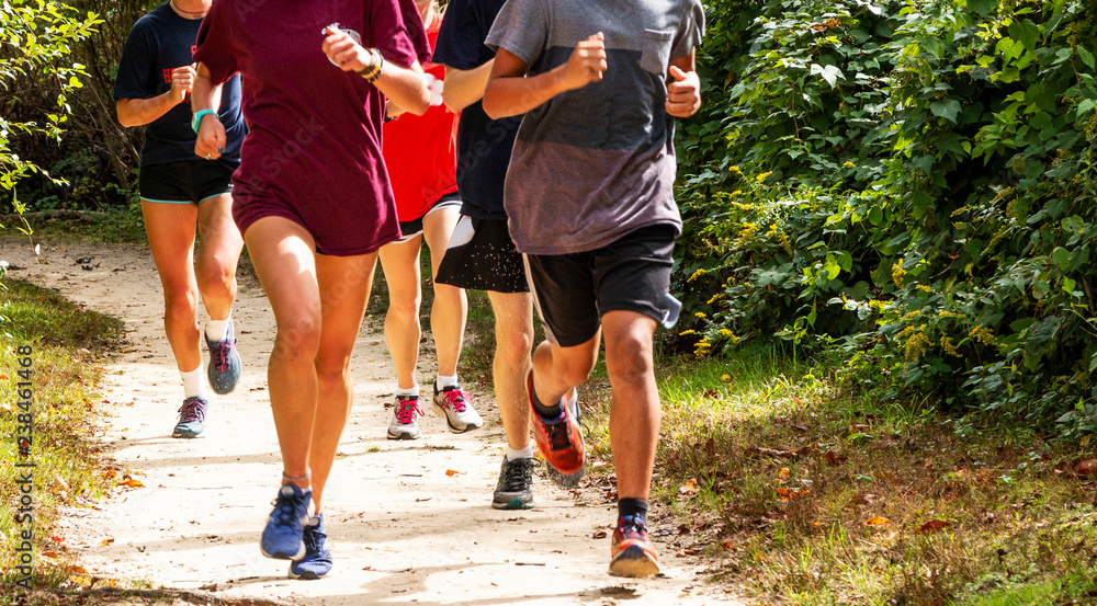 © coachwood - Group of runners on a dirt trail running © coachwood - Group of runners on a dirt trail running
