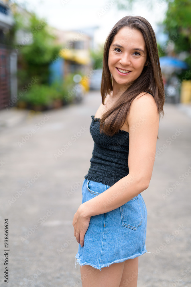 Young happy multi-ethnic woman smiling in the streets outdoors
