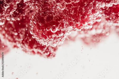 Fresh raspberries in water wiht air bubbles.