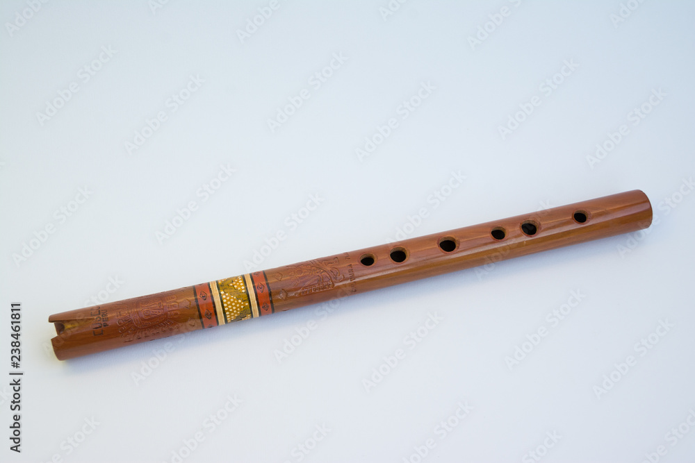 Old Quena of Peru (traditional flute of the Andes), with 37 notes and three octaves, 37 cm long. It consists of a tube with a simple notch, has six front holes, one back. Isolated on white background. Old Quena of Peru (traditional flute of the Andes), with 37 notes and three octaves, 37 cm long. It consists of a tube with a simple notch, has six front holes, one back. Isolated on white background.