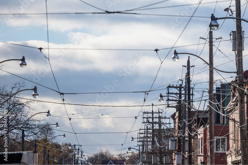 Electric power lines, on wooden poles, electricity supply, phone lines and streetcar cables, abiding by North American standards, in the city of Toronto, Ontario, Canada