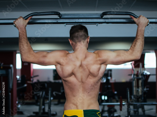 Muscle man making pull-up on horizontal bar © Nikita Vasilchenko