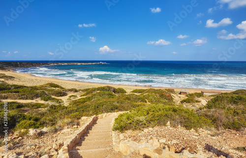 Beautiful wild beach with clear turquoise water and waves.