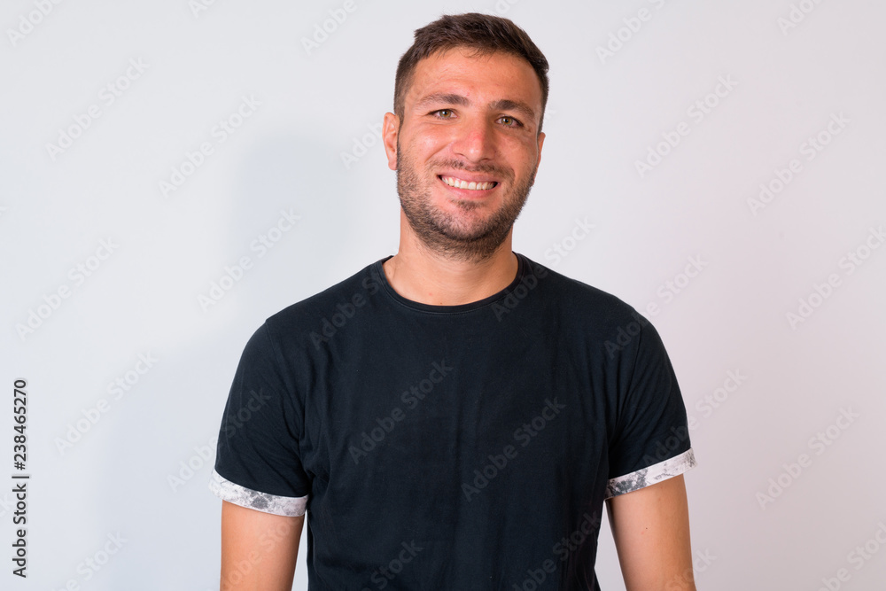 Fototapeta premium Happy handsome bearded Persian man smiling against white background