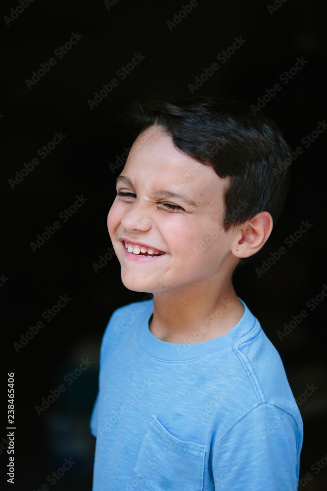 Close-up portrait of happy boy standing in darkroom at home Close-up portrait of happy boy standing in darkroom at home